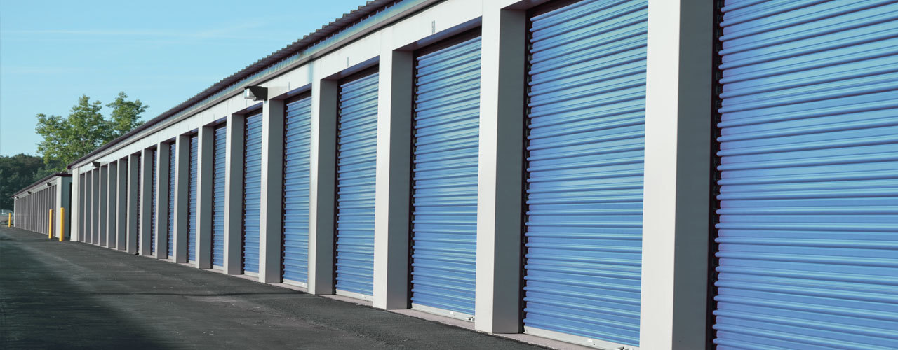 Row of clean blue drive-up storage units at Tony's Self Storage